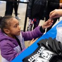 Little girl grabs something from someone's hand